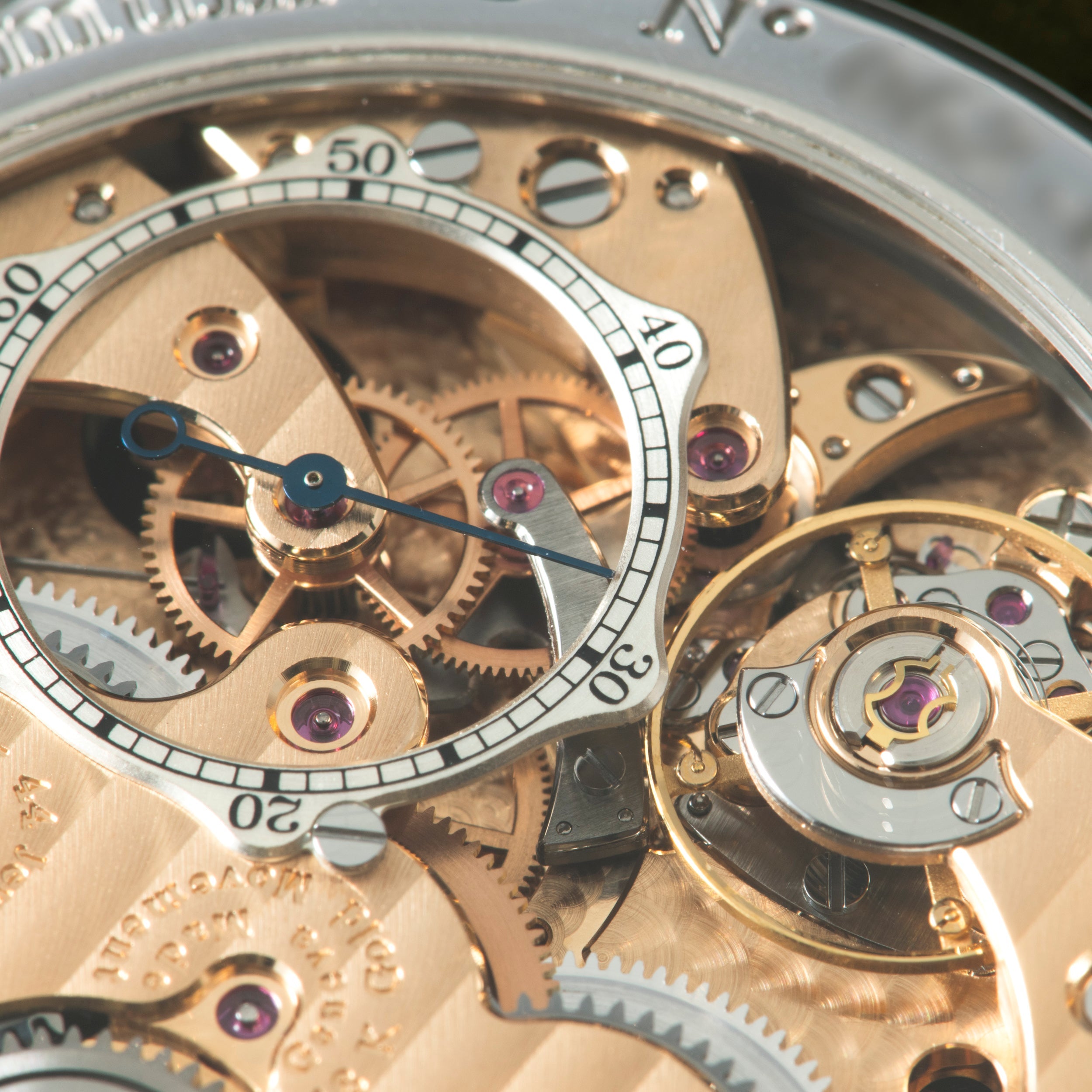 Luxury watch dial with exposed rose gold movement, blue hands, numbered chronograph subdials, and purple jeweled components v
