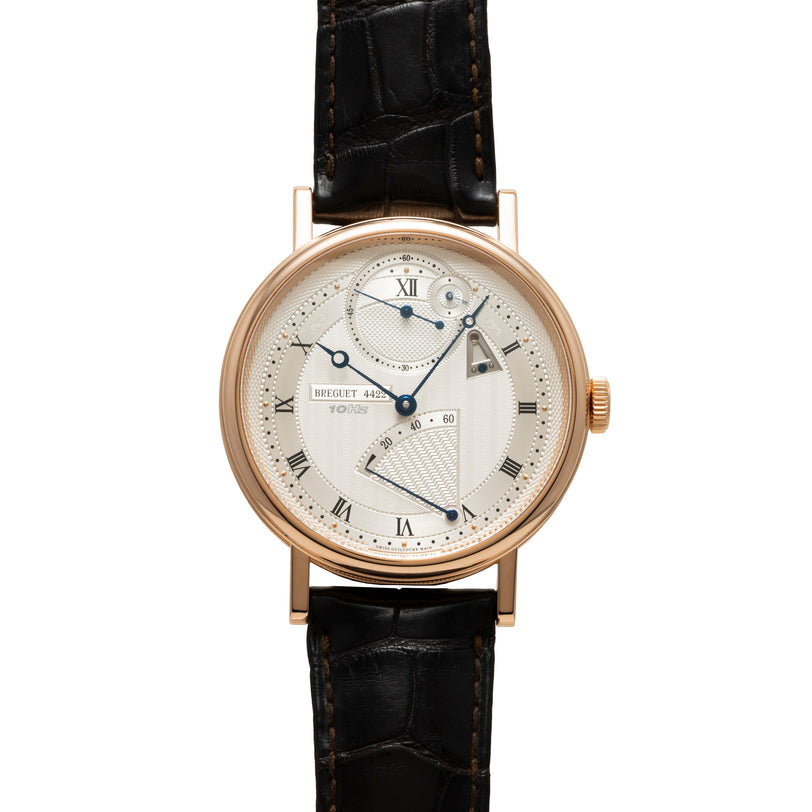 Rose gold round watch with cream dial, Roman numerals, and black crocodile leather strap.