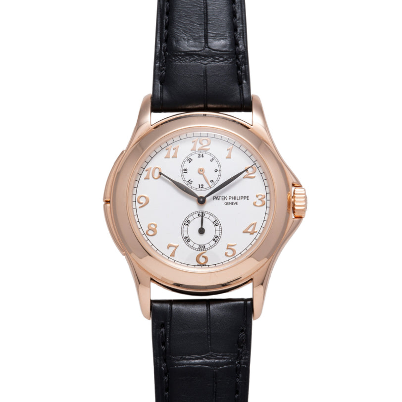 Rose gold watch with white dial, Arabic numerals, two subdials, and black leather strap.