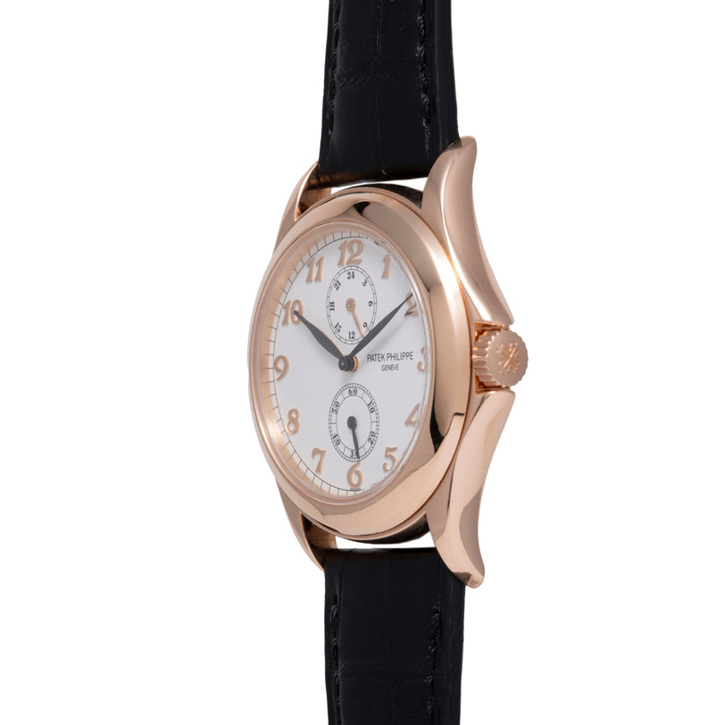 Rose gold watch with silver dial, Arabic numerals, two subdials, and black leather strap.