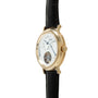 Gold-toned oval watch with white dial, Roman numerals, visible tourbillon escapement at bottom, and black crocodile leather s