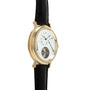 Gold-tone watch with white dial, Roman numerals, visible tourbillon at 6 o'clock, and black leather strap.