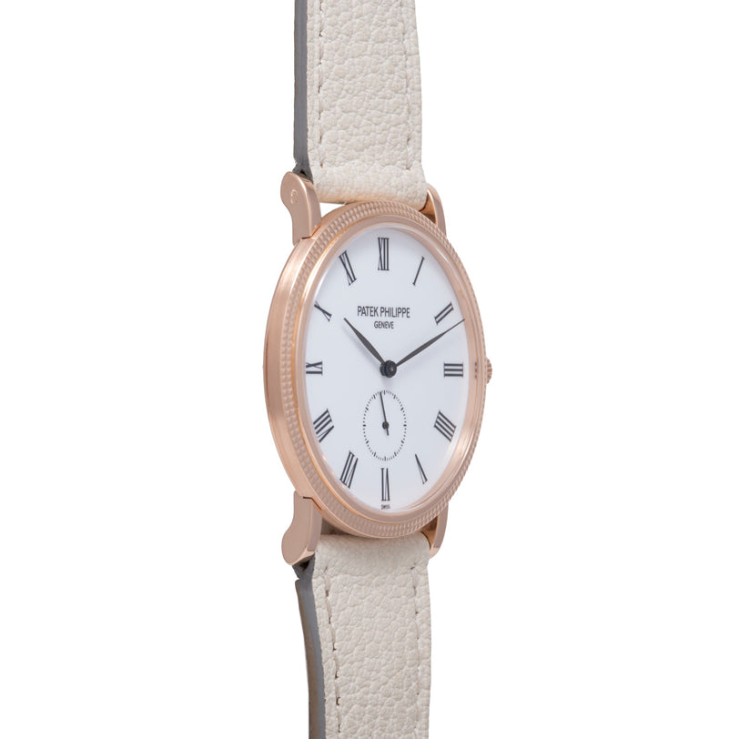 Rose gold oval watch with white dial, Roman numeral markers, subdial, and cream leather strap.