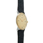 Hermès wristwatch with oval cream dial, gold-tone hands and indices, two-tone case, and black textured leather strap.