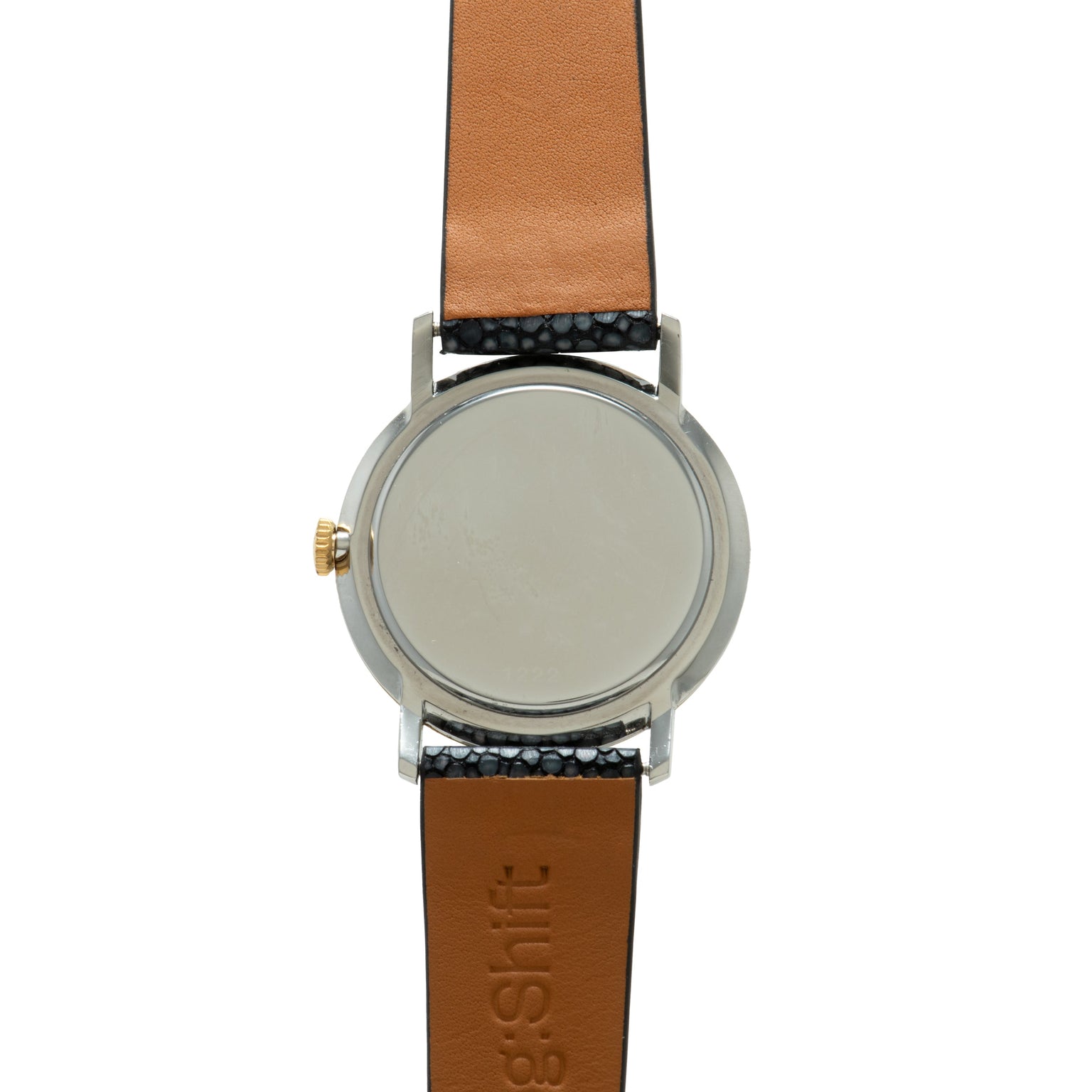 Stainless steel watch with blank silver dial, gold crown, and tan leather strap with black textured band detail.