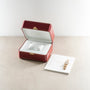 Rose gold rectangular wristwatch with diamond bezel displayed in burgundy Cartier box and on white card.