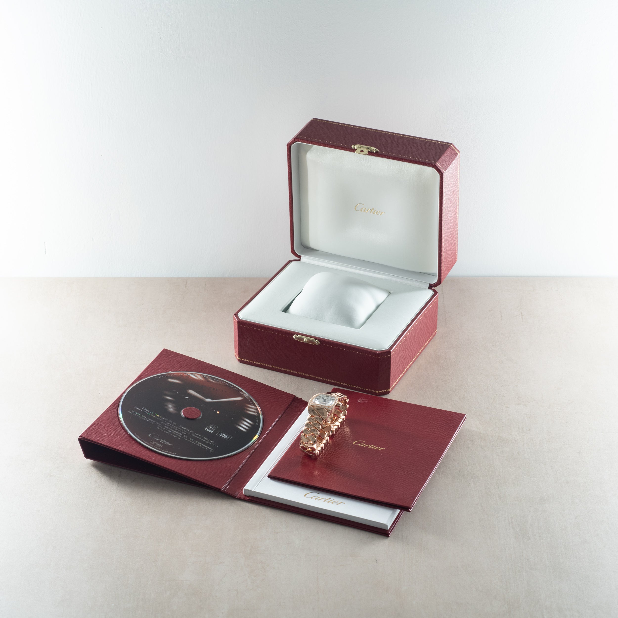 Cartier La Doña de Cartier rose gold ring displayed with burgundy box, DVD, and documentation.