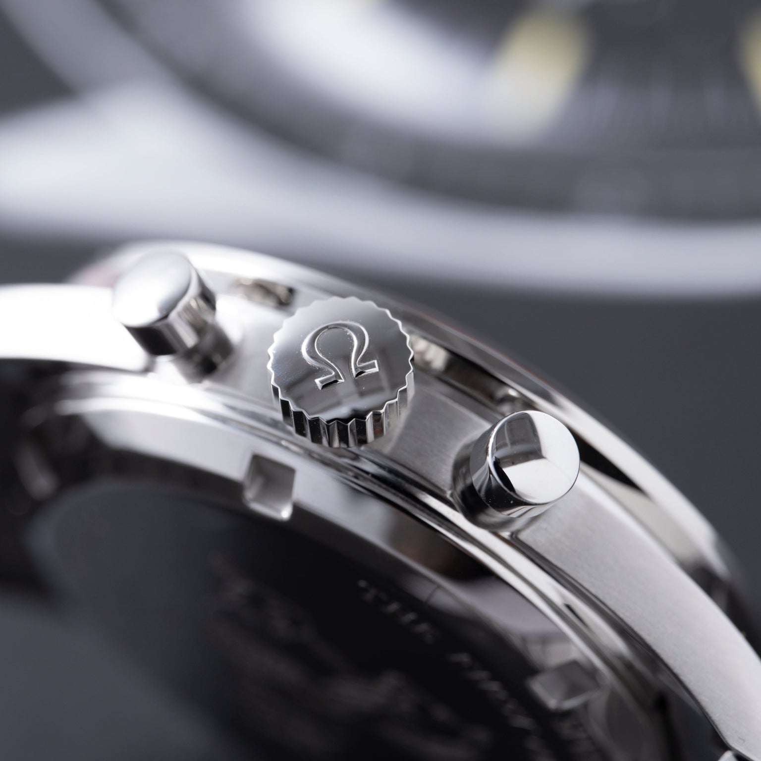 Stainless steel chronograph watch with Omega logo on crown and pushers, showing polished case and bracelet detail.