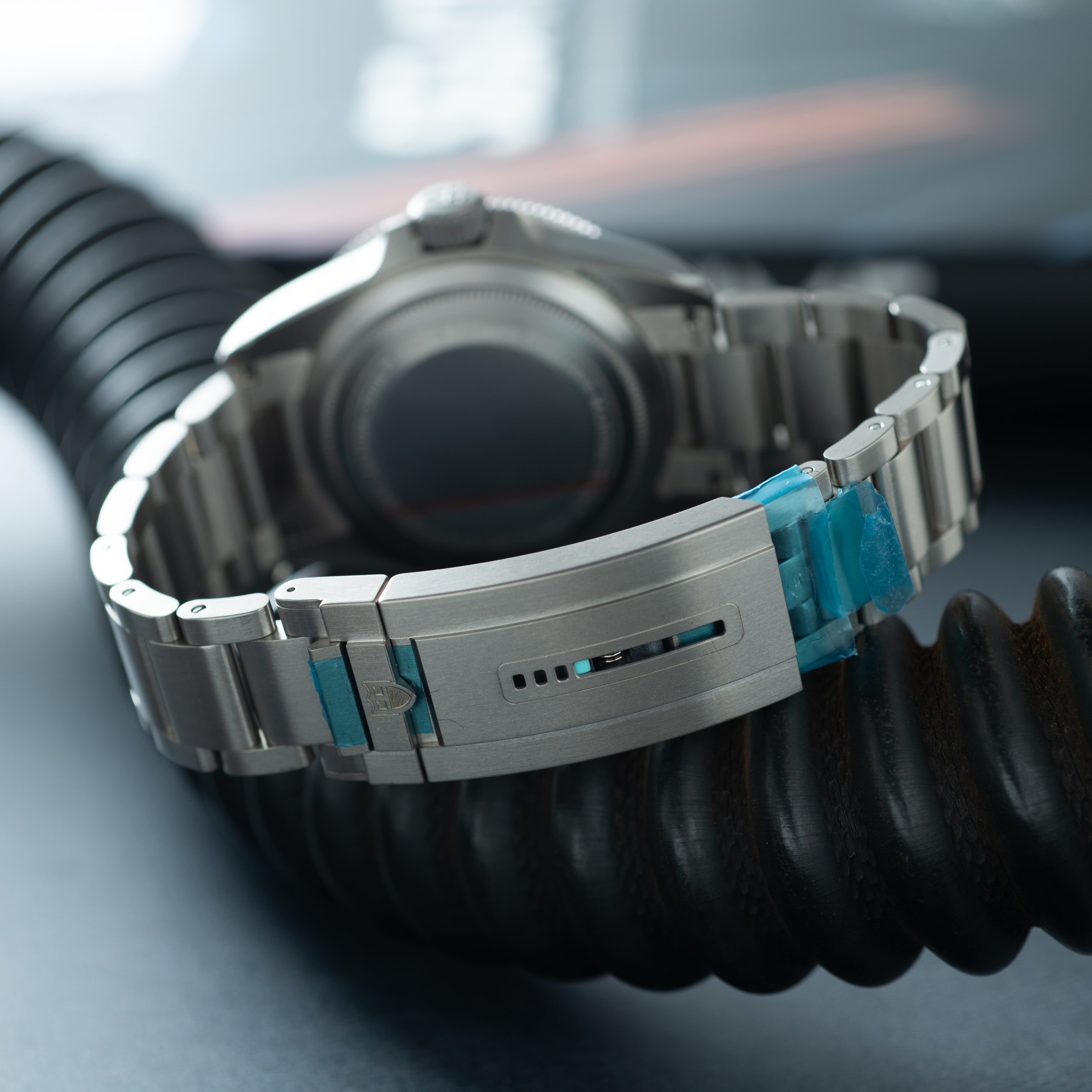 Tudor Pelagos Ultra dive watch with titanium case, black dial, and metal bracelet with blue accents.