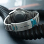 Tudor Pelagos Ultra dive watch with titanium case, black dial, and metal bracelet with blue accents.