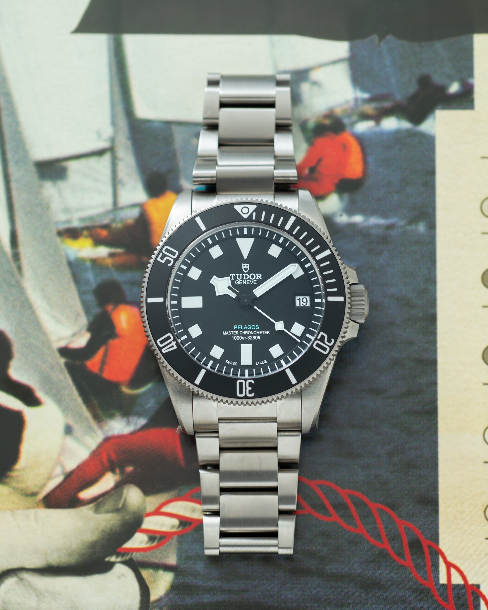 Tudor Pelagos Ultra stainless steel watch with black dial, white hour markers, date window, and metal bracelet.