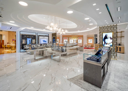 A modern jewelry store with glass display cases, bright lighting, and polished marble floors.