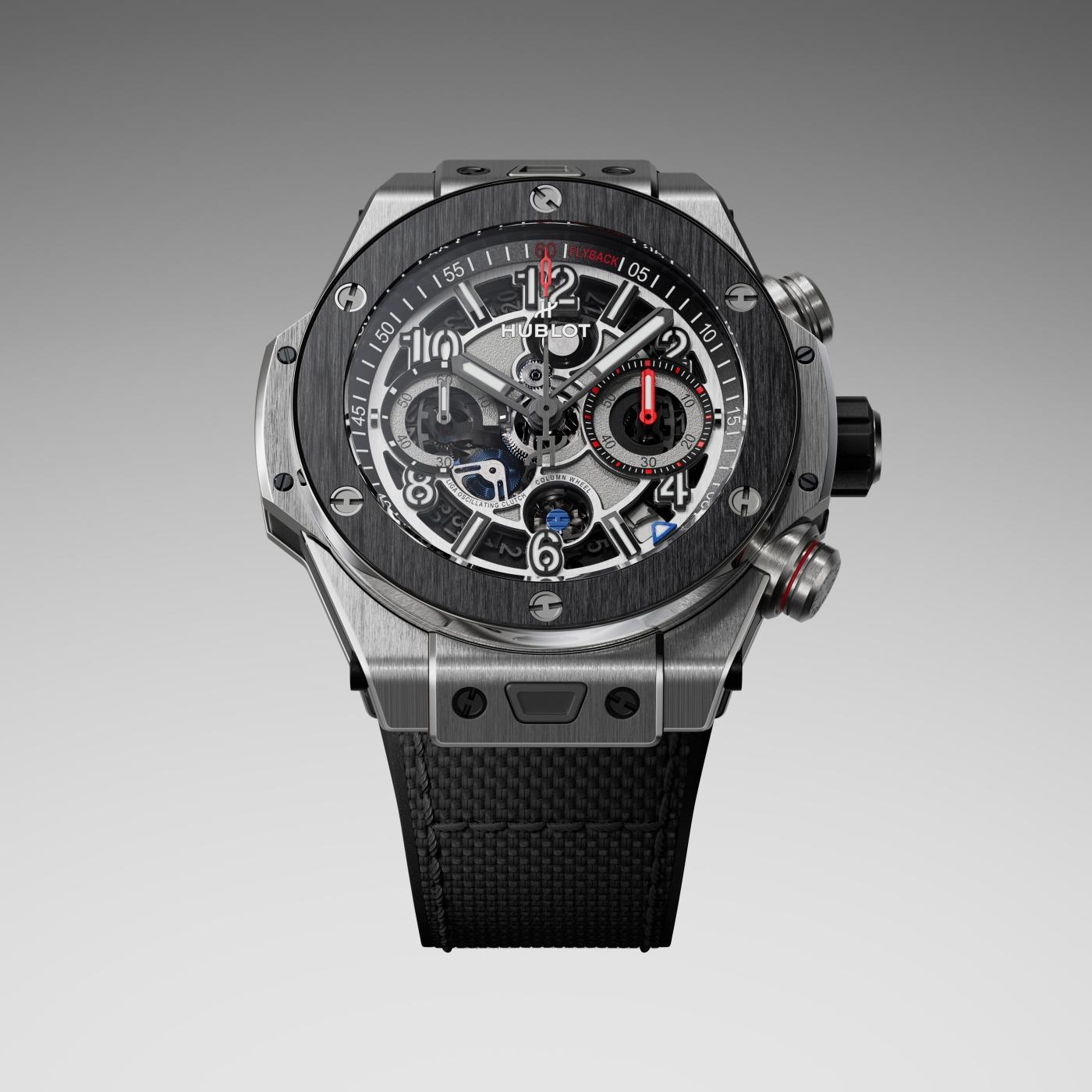 Stainless steel and black ceramic chronograph watch with exposed skeleton dial, red accents, and black rubber strap.