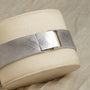A Vacheron Constantin White Gold Diamond Bezel bracelet with a clasp, elegantly displayed on a beige cushioned stand.