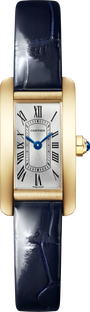 The Cartier Tank Américaine features a luxurious gold rectangular case, white dial with black Roman numerals, blue hands, and a dark blue leather strap—a true timeless classic.