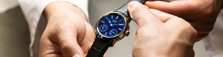 Watchmakers holding a leather strap steel case watch 