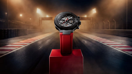 Watch on a red stand with a racing track background