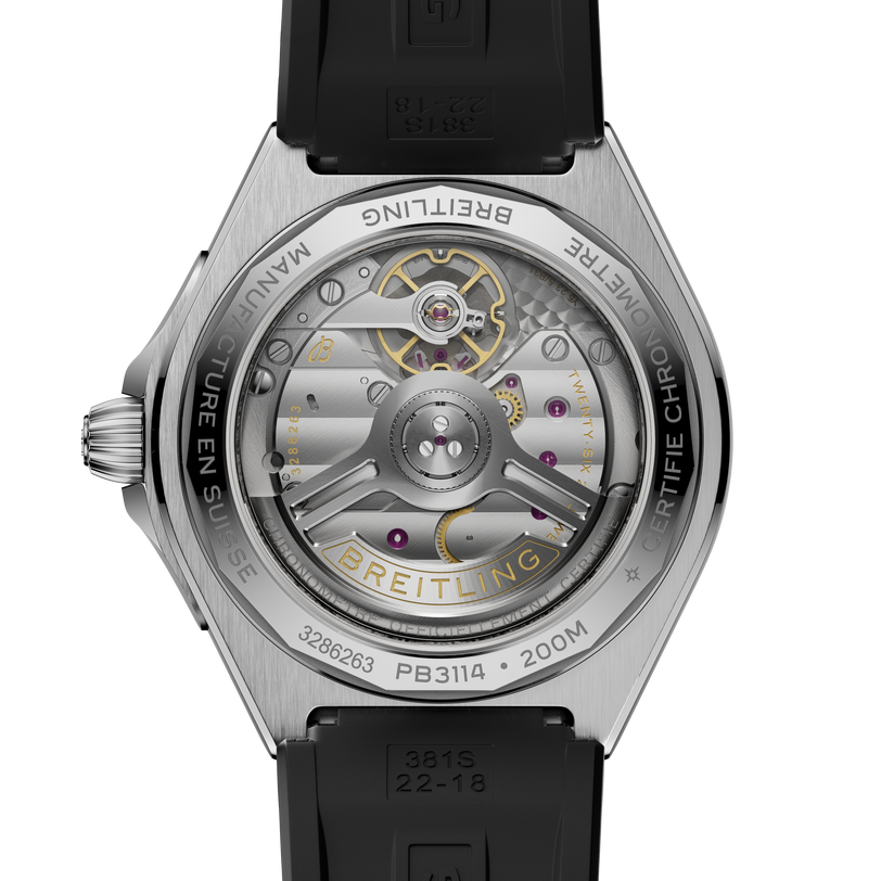 Silver-tone watch with black rubber strap displaying exposed automatic movement through transparent caseback with gold accent