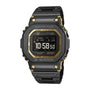 Black stainless steel G-Shock digital watch with gold accents, square face, and metal band displaying time 10:58.