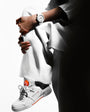 Person wearing white blazer and sneaker with wrist pump device visible on arm.