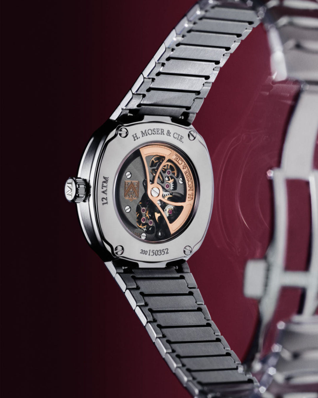H. Moser & Cie stainless steel watch with black link bracelet and exposed skeleton dial showing rose gold and black mechanism