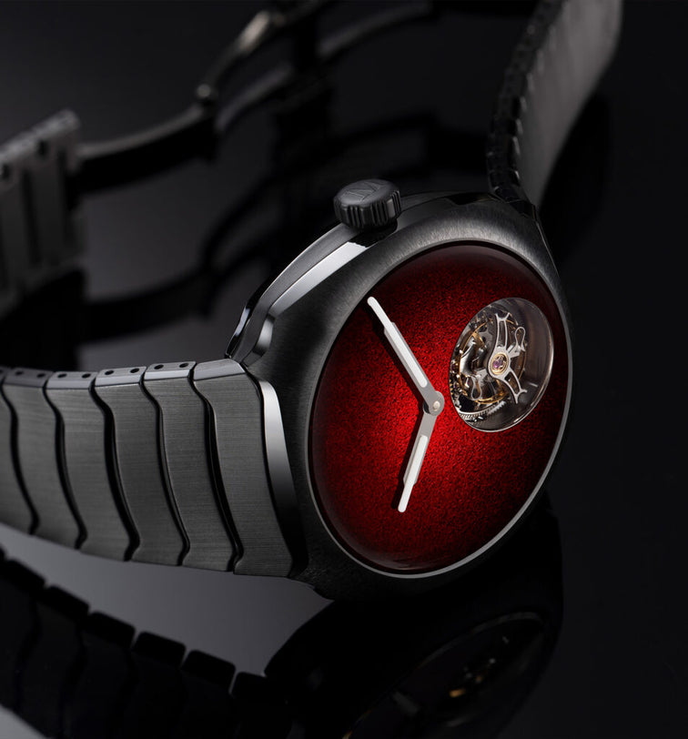 Watch with a red face and metallic strap on a dark background