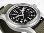 Hamilton watch with black dial and green strap on a white background