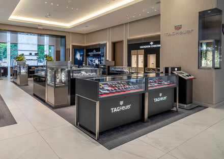 Modern luxury watch store interior with TAG Heuer displays and glass cases showcasing watches.