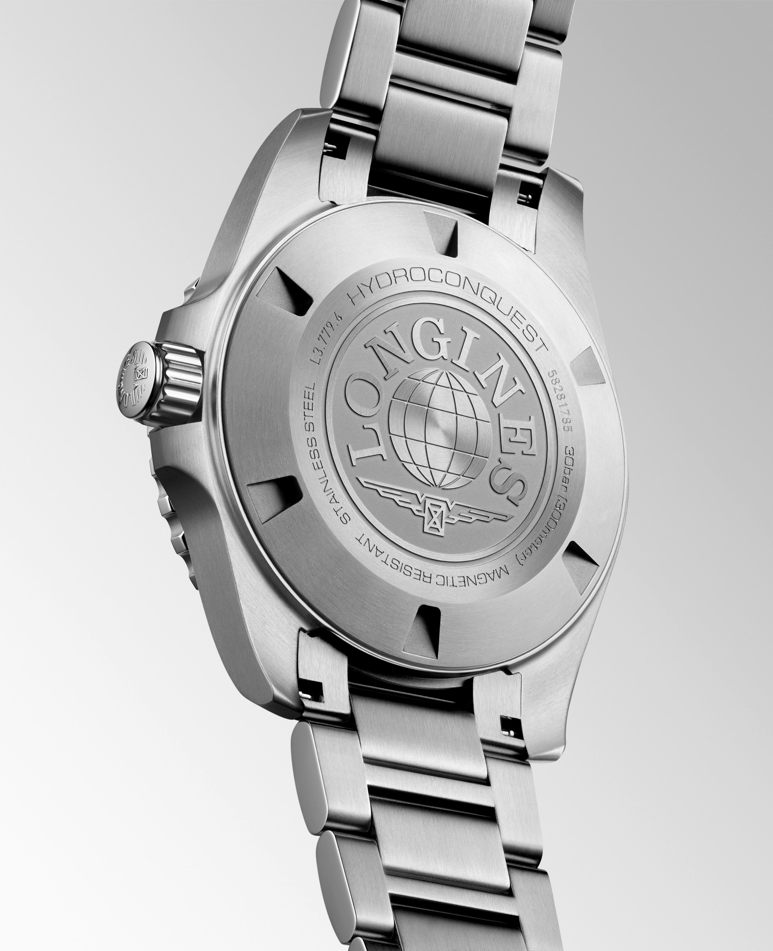 Close-up of a silver watch with brand engraving on a light gray background