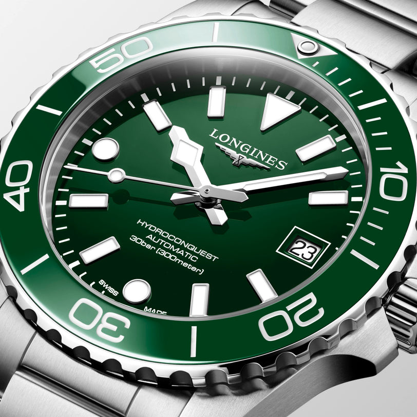 Longines watch with green dial and silver case on a white background