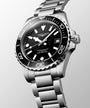 Longines watch with black dial and silver bracelet on a light gray background