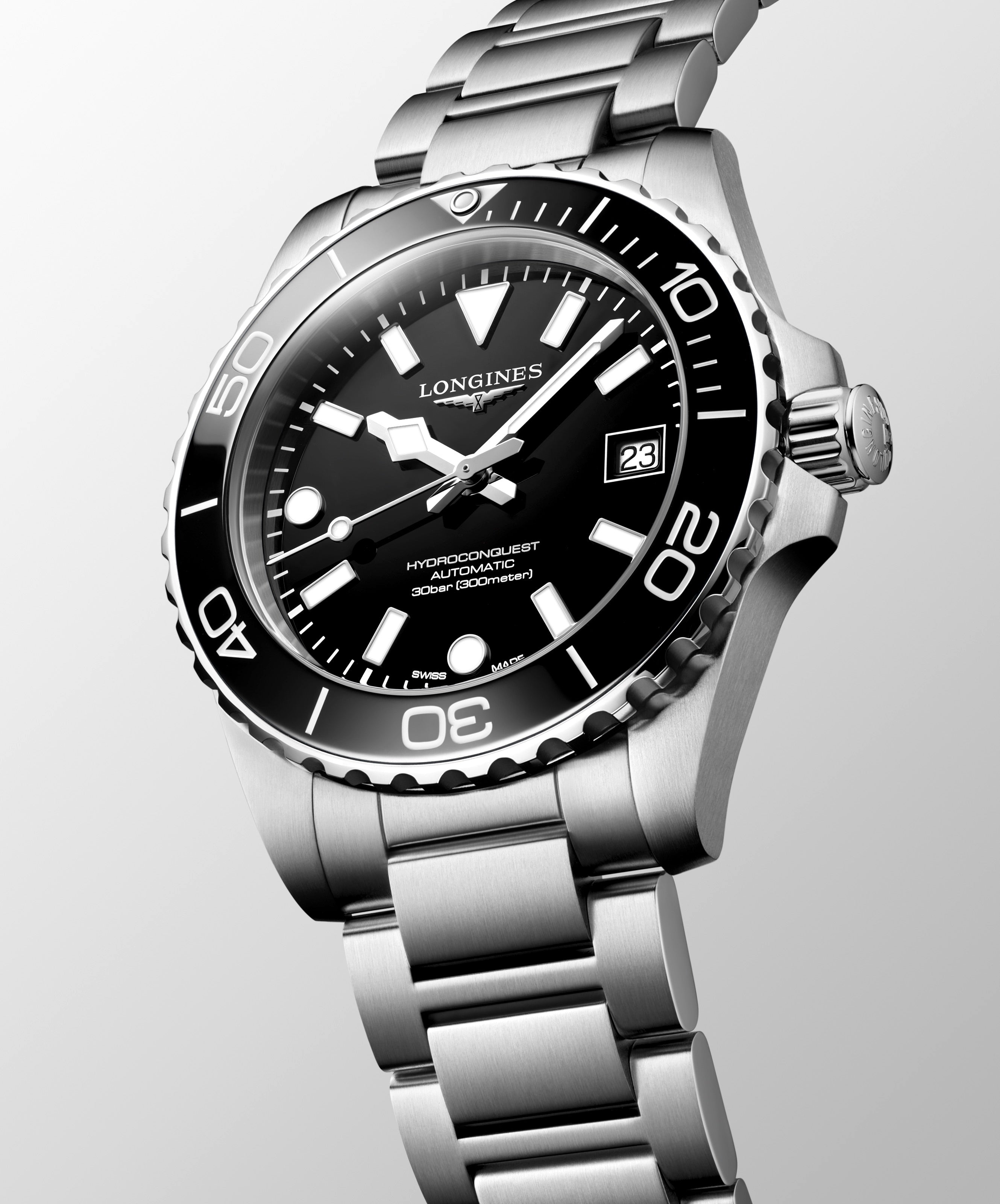 Longines watch with black dial and silver bracelet on a light gray background