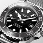 Longines watch with black dial and silver metal bracelet on a light gray background