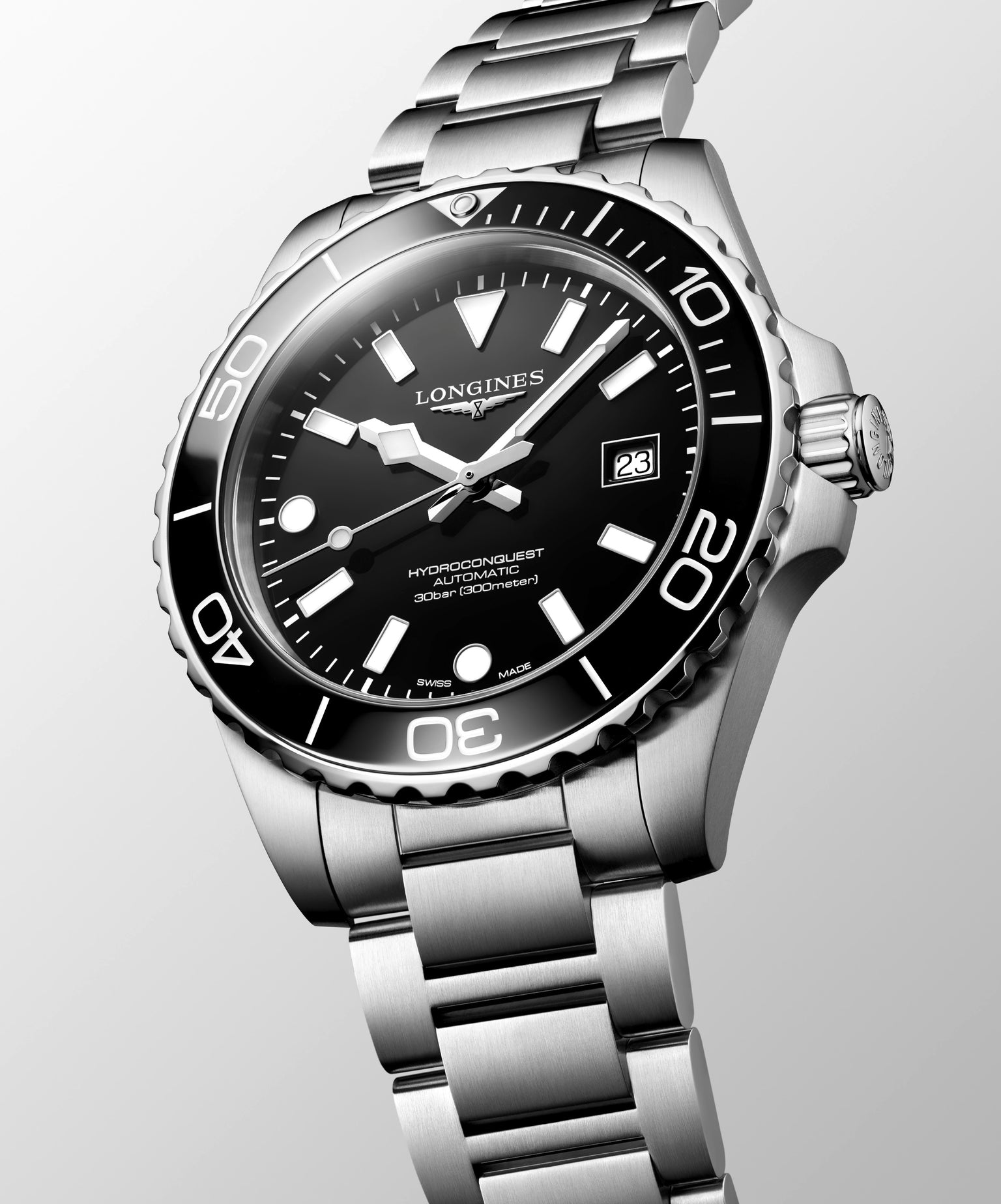 Longines watch with black dial and silver bracelet on a light gray background