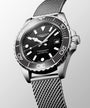 Longines watch with black dial and silver mesh band on a light gray background