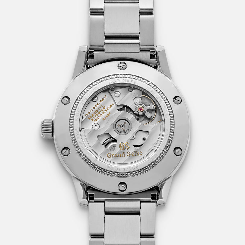 Close-up of the Grand Seiko Automatic GMT SBGM239 Limited Edition for HODINKEE shows its exposed mechanical movement, engraved details, and stainless steel bracelet—highlighting a masterpiece from Grand Seiko.