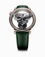 The MB&F SP One Rose Gold is a luxury watch featuring exposed gears, a black dial, and a green leather strap, showcased on a white background.