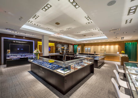 A luxury watch store interior with glass display cases and branded sections for TAG Heuer and Rolex.