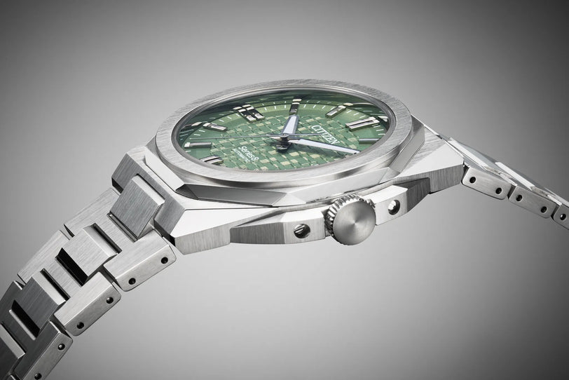Stainless steel watch with green dial, 39mm case, metal band, and three subdials.