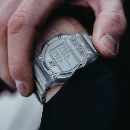 Digital watch held in a hand with a blurred background
