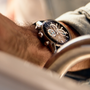 Close-up of a persons wrist wearing the TAG Heuer Carrera Chronograph Seafarer × Hodinkee, a black watch by TAG Heuer featuring silver details and a leather strap.