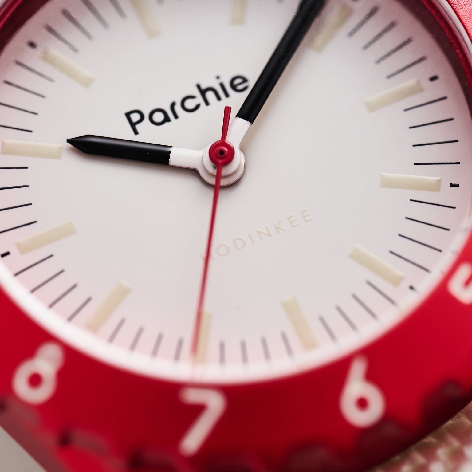 Close-up of a red Parchie Lunar-Time Limited Editions for Hodinkee 32 wristwatch displaying the time as 9:05:31.