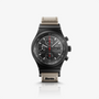 The Porsche Design Chronograph 1 50 Years 911 Turbo Edition features a black dial with red accents, a black bezel, and a beige fabric strap.