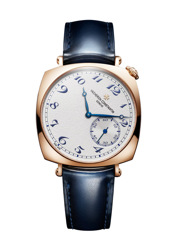 Rose gold square watch with cream dial, blue Arabic numerals, blue leather strap, and small seconds subdial.