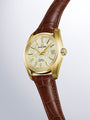 Grand Seiko Hi-Beat 36000 automatic watch with gold-tone case, cream dial, gold hour markers, date window, and brown crocodil