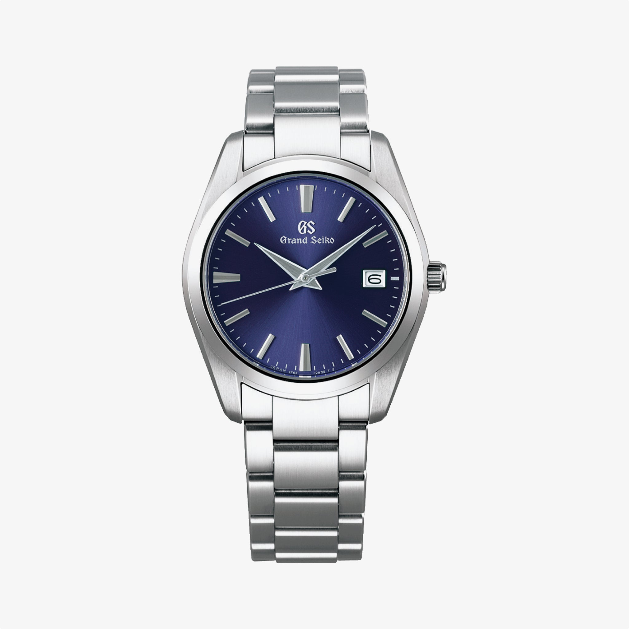 The Grand Seiko Heritage Quartz Blue features a stainless steel case, silver strap, bold blue dial, silver hour markers and hands, plus a date window at 3 o’clock—all showcased against a white background.