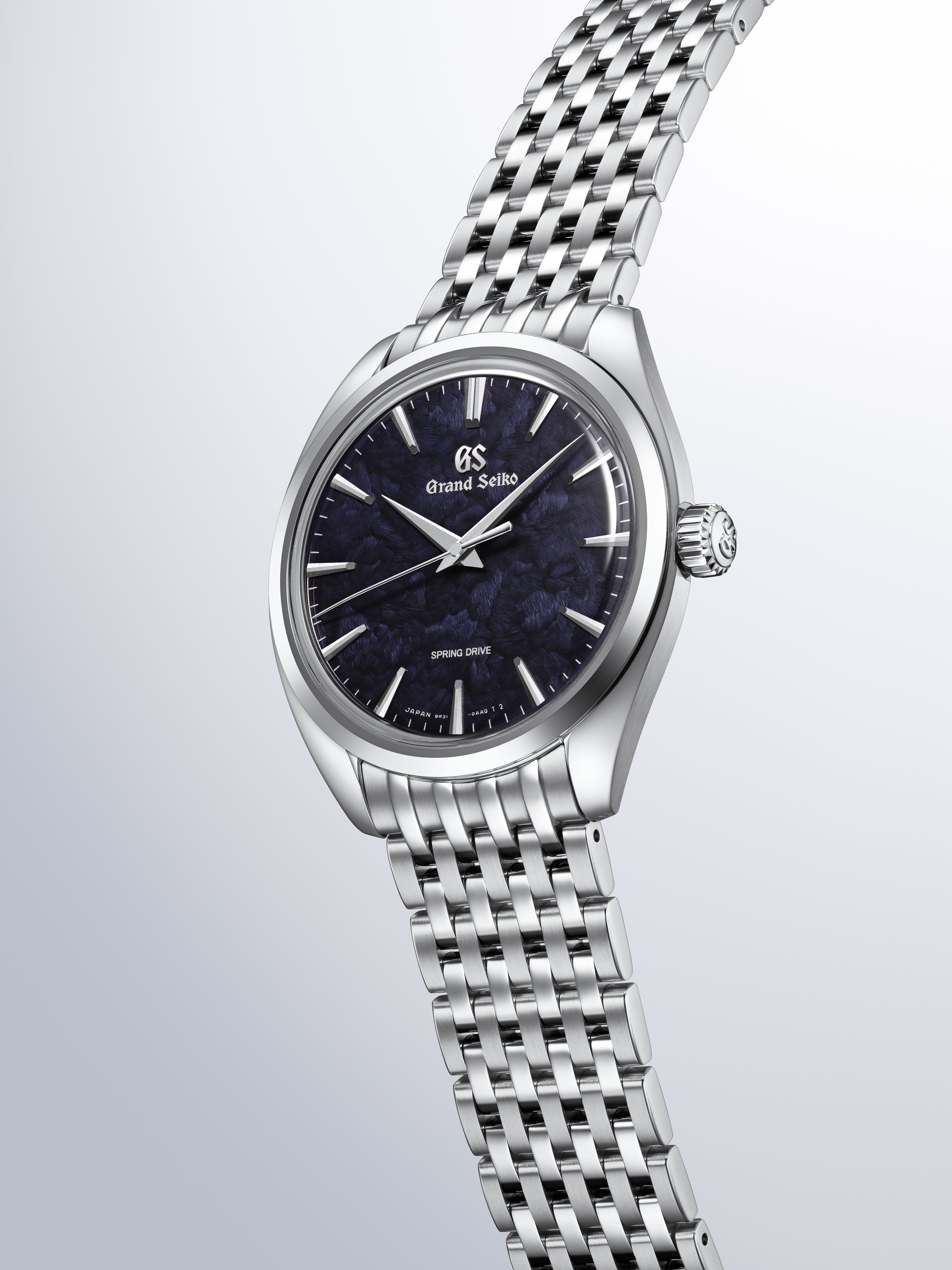 Grand Seiko stainless steel watch with dark blue dial, white hour markers, and matching metal bracelet.