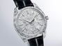 Silver-tone watch with textured case, patterned dial, applied hour markers, and black leather strap.