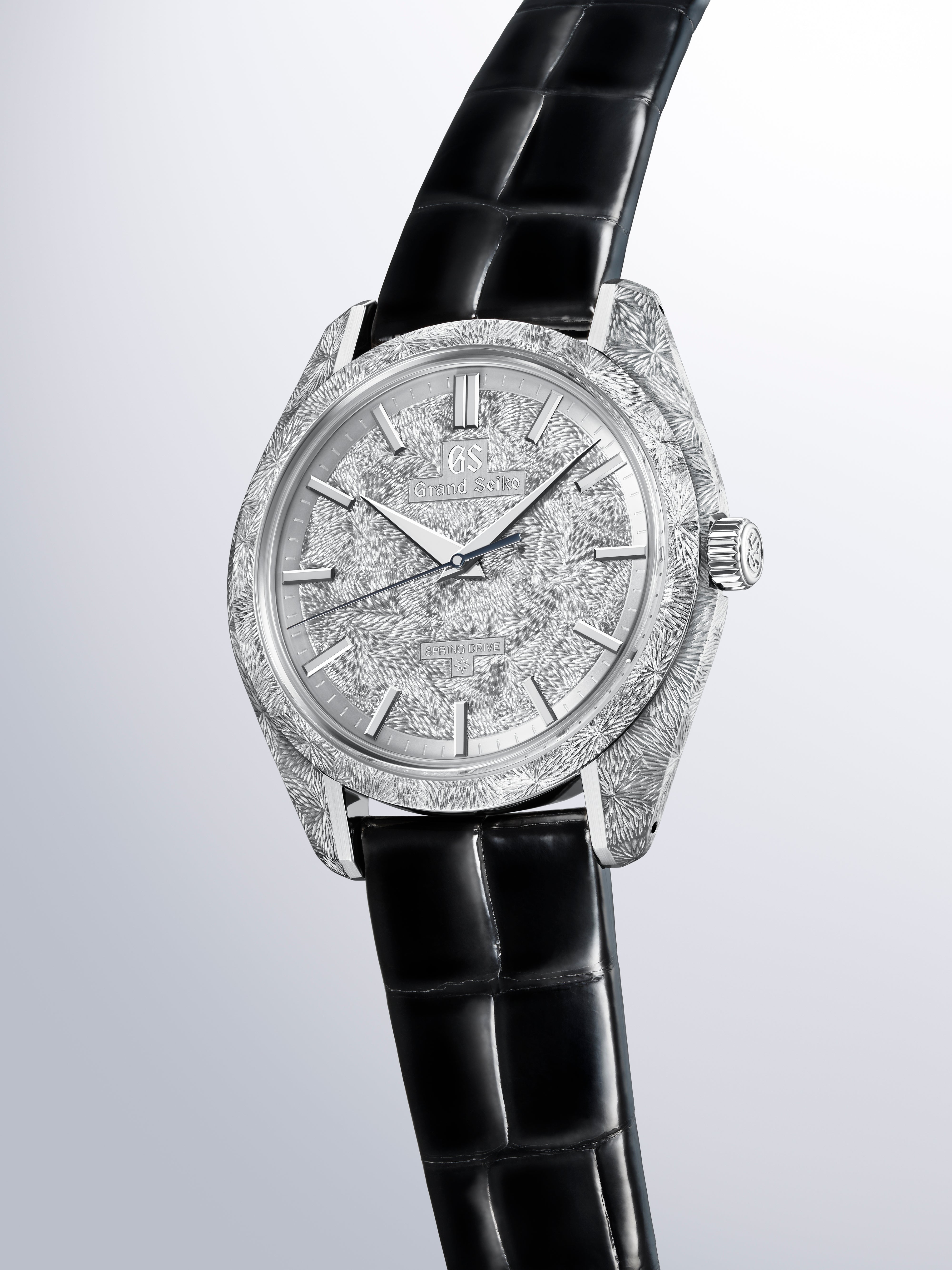 Silver watch with textured case and dial, black crocodile leather strap, applied indices and hands.