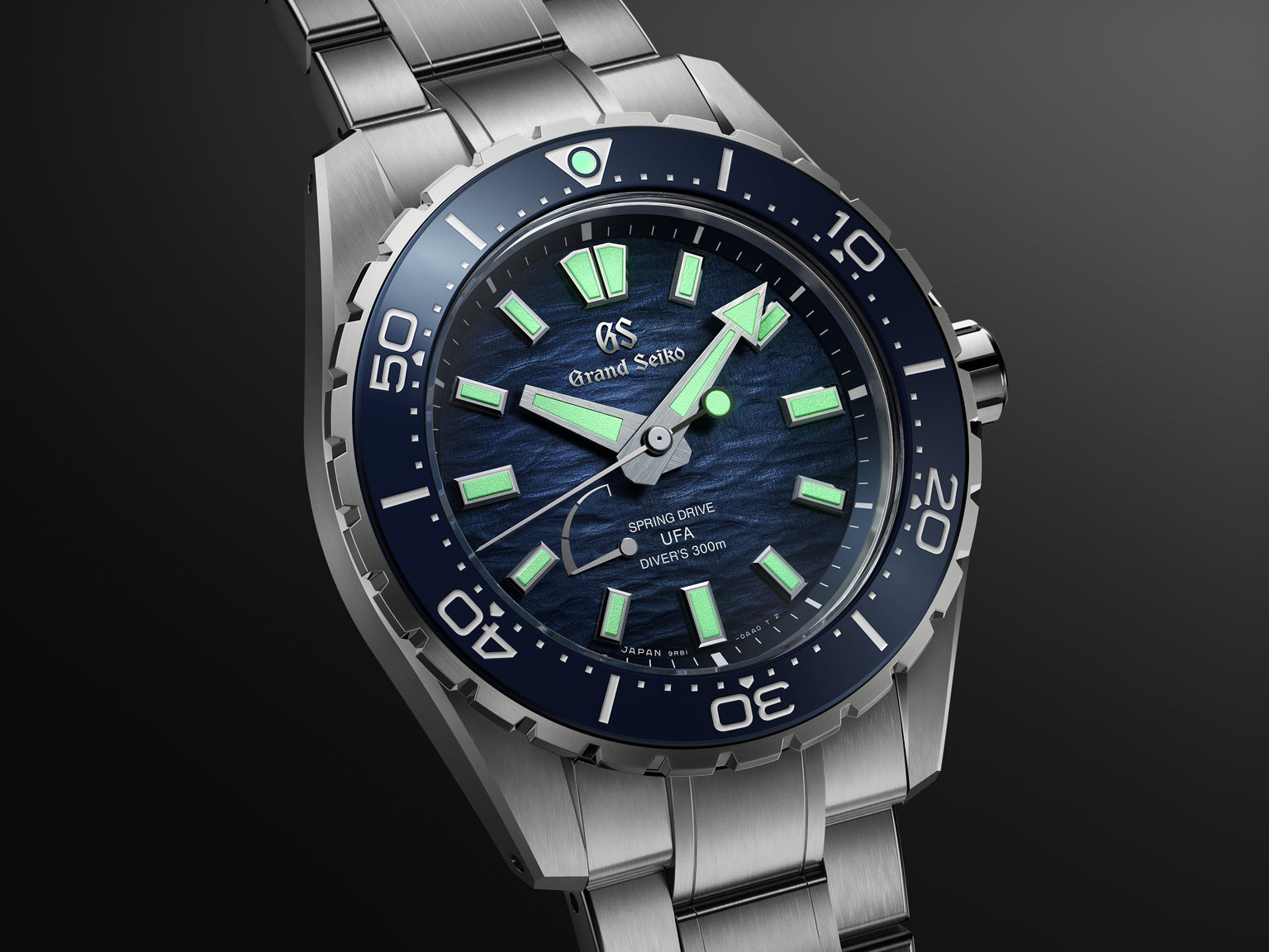 Silver stainless steel diver watch with dark blue dial, luminous hour markers, and matching bezel.